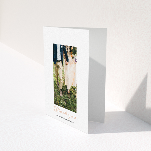 A wedding thank you card template titled "Small and Central". It is an A6 card in a portrait orientation. It is a photographic wedding thank you card with room for 1 photo. "Small and Central" is available as a folded card, with tones of white and pink.
