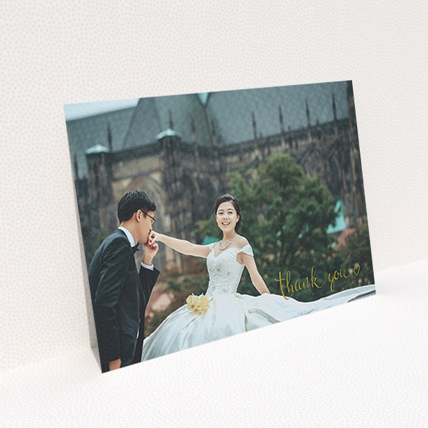 A wedding thank you card called "Thank you with a heart". It is an A6 card in a landscape orientation. It is a photographic wedding thank you card with room for 1 photo. "Thank you with a heart" is available as a flat card, with mainly gold colouring.