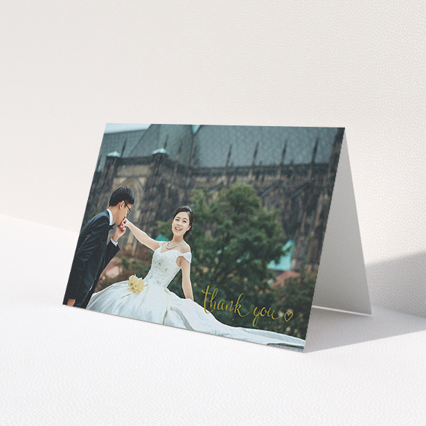 A wedding thank you card named 'Thank you with a heart'. It is an A6 card in a landscape orientation. It is a photographic wedding thank you card with room for 1 photo. 'Thank you with a heart' is available as a folded card, with mainly gold colouring.
