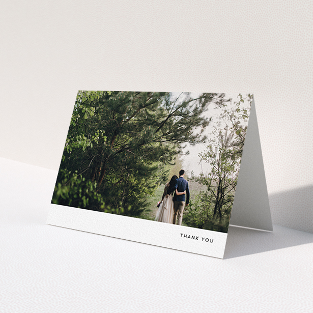 A wedding thank you card design titled 'Thankful with Simplicity'. It is an A6 card in a landscape orientation. It is a photographic wedding thank you card with room for 1 photo. 'Thankful with Simplicity' is available as a folded card, with mainly white colouring.
