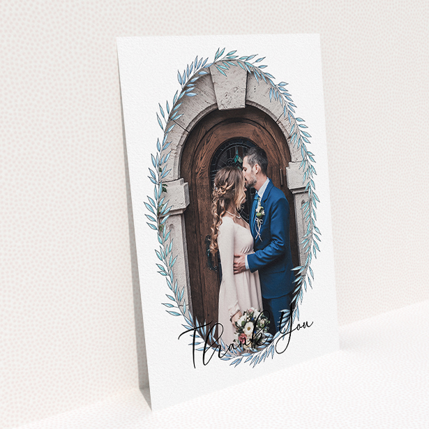 A wedding thank you card design called "Tussled Wreath Frame". It is an A5 card in a portrait orientation. It is a photographic wedding thank you card with room for 1 photo. "Tussled Wreath Frame" is available as a flat card, with mainly blue colouring.