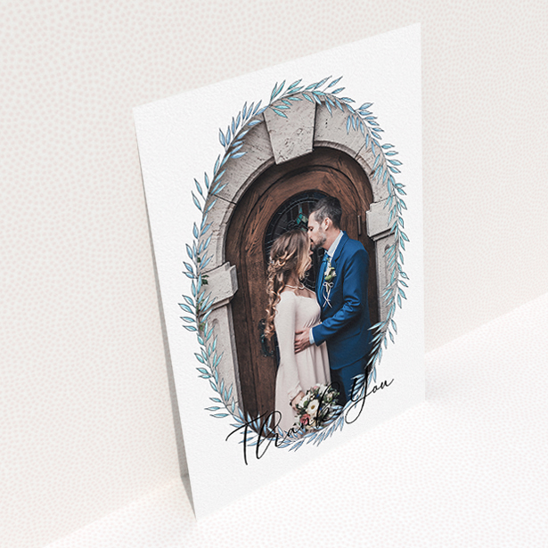 A wedding thank you card design called "Tussled Wreath Frame". It is an A5 card in a portrait orientation. It is a photographic wedding thank you card with room for 1 photo. "Tussled Wreath Frame" is available as a flat card, with mainly blue colouring.