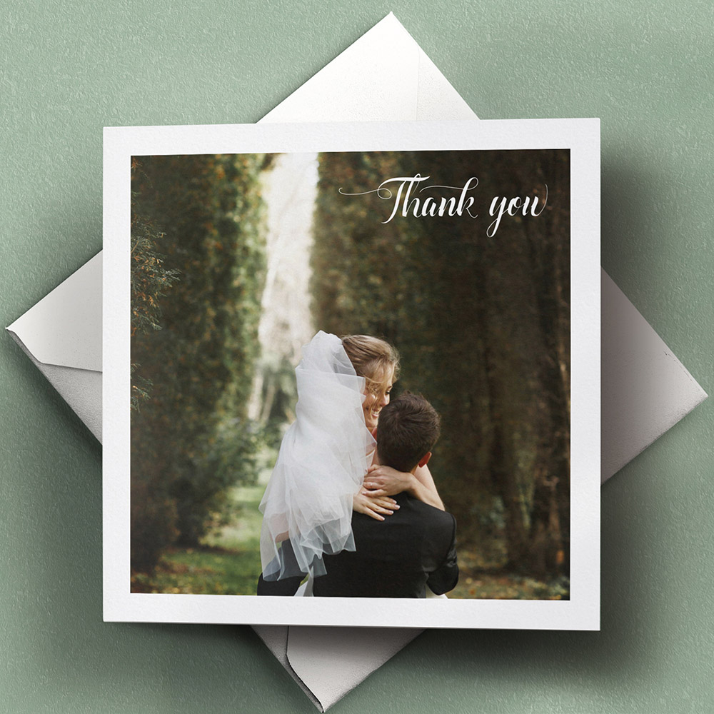 A white, square folded wedding thank you card with a classic style.