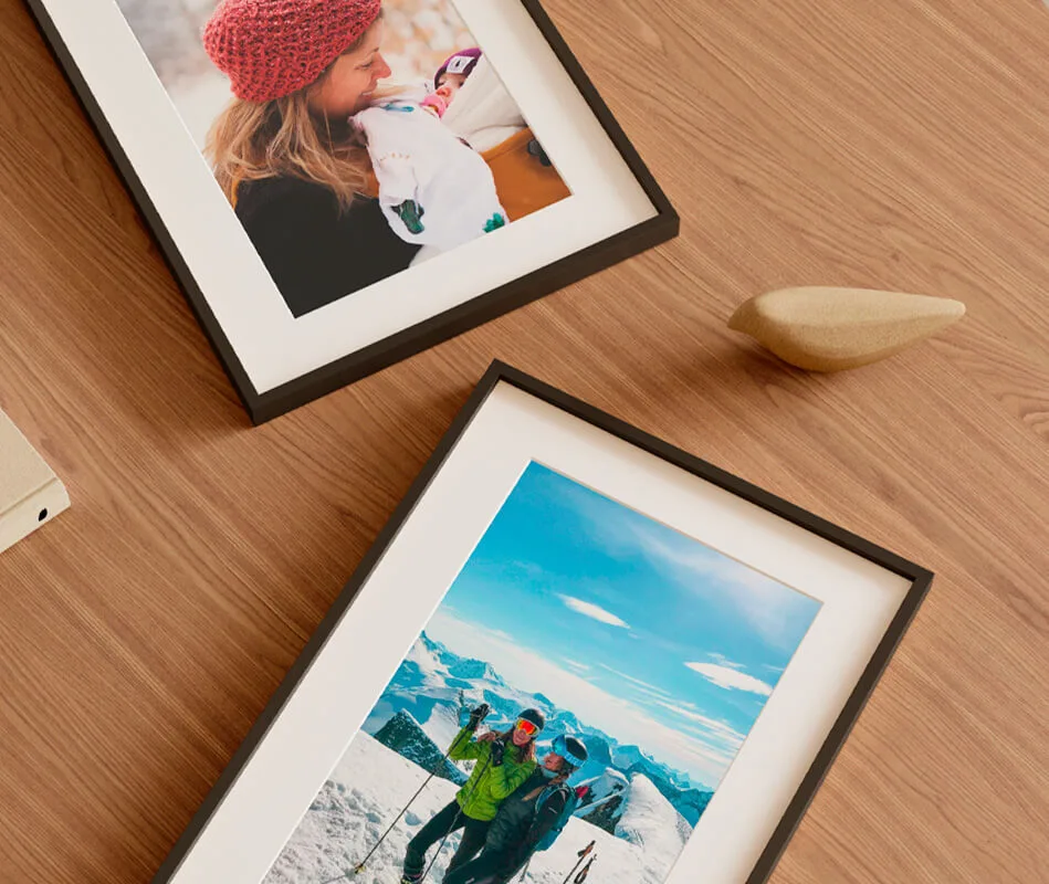 Elegant sustainable framed prints featuring vibrant photography, displayed on a natural wooden table