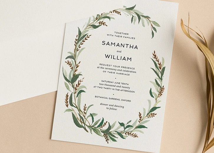 Wedding invitation featuring a delicate botanical wreath in natural green tones.