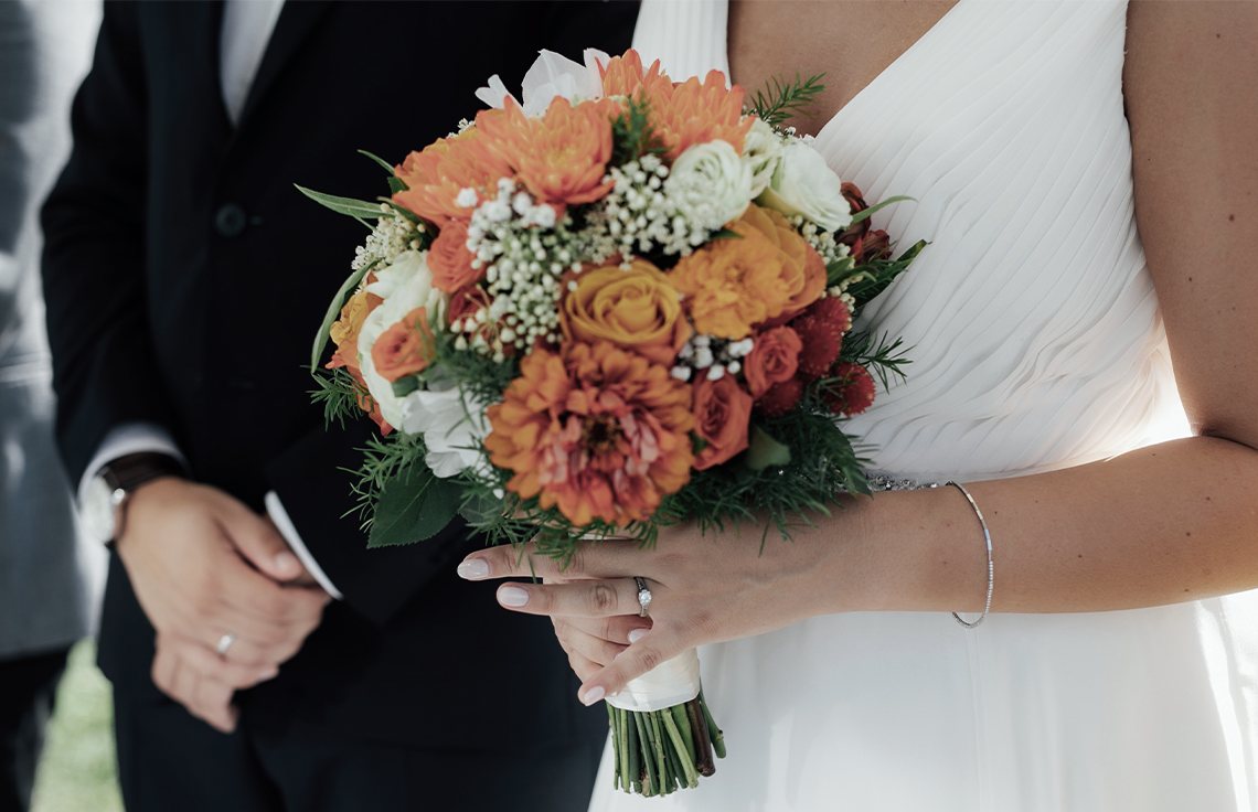 Couple getting married orange bouquet ceremony