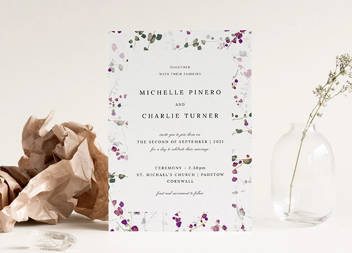 Beautiful wedding invitation with floral border and pastel design elements.