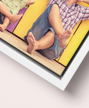 Close-up of a colourful, playful family photo print on canvas in a white wooden frame