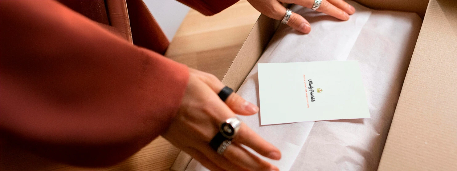 Close-up of hands packing a premium stationery box with personalised thank-you notes