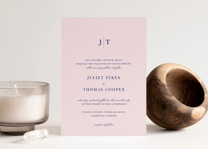 Minimalist pink wedding invitation with elegant typography and modern design.