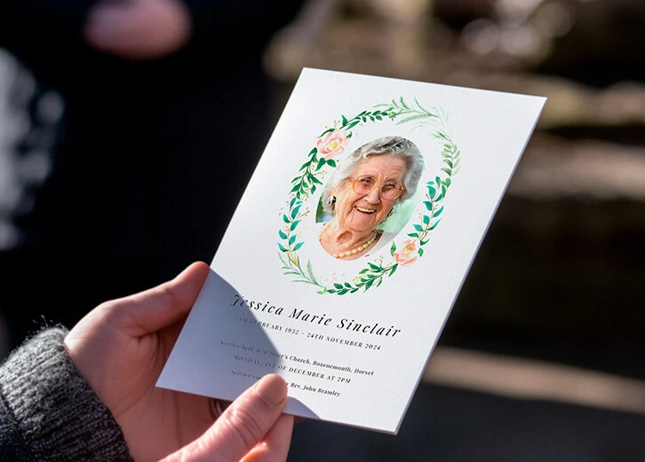 Personalised funeral order of service card featuring a floral wreath and a cherished photo