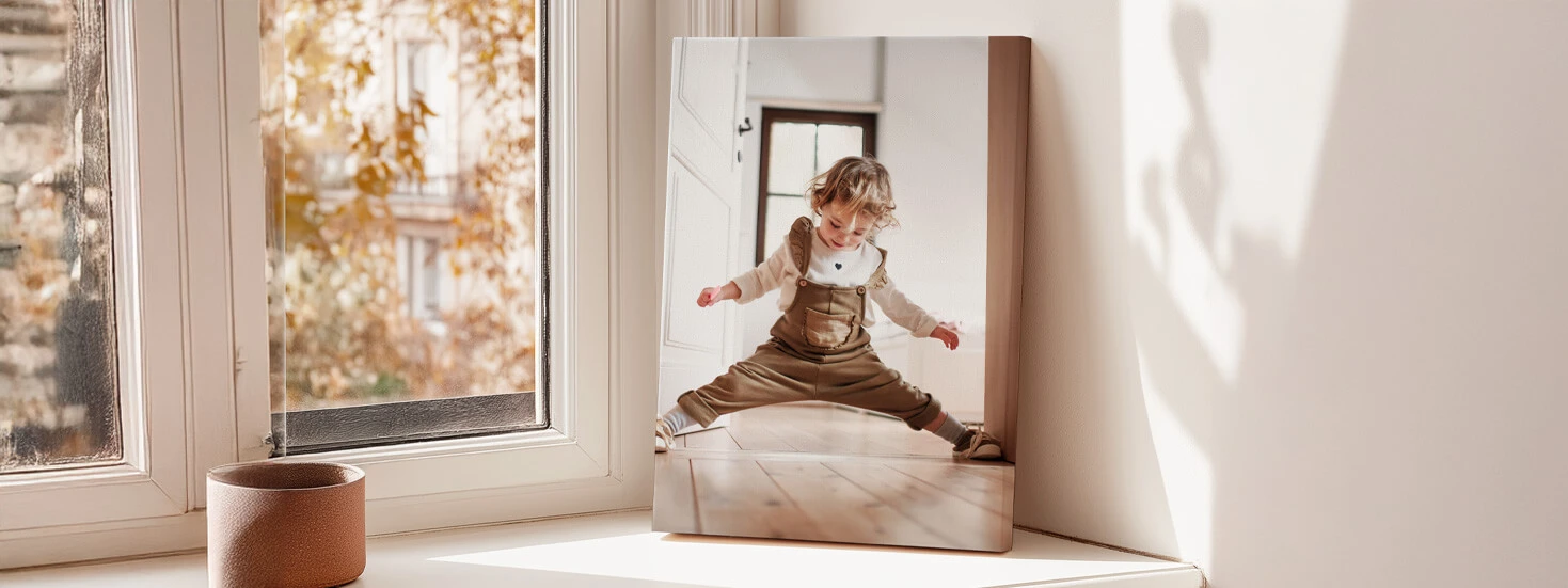 Personalised photo canvas displayed in a bright room on a windowsill with autumn views