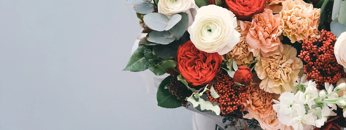 Vibrant floral bouquet with autumnal tones, featuring roses and eucalyptus leaves