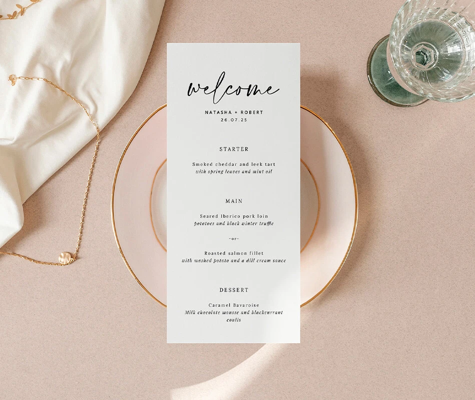 Minimalist wedding menu with elegant typography placed on a dinner table