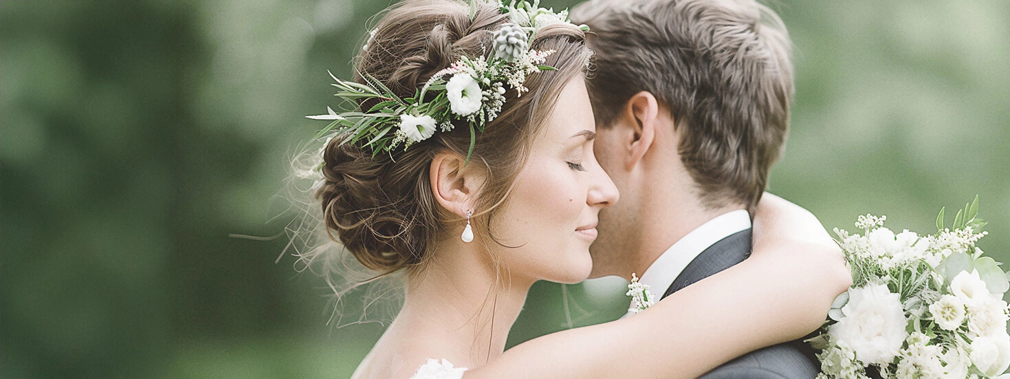 Beautiful bride and groom embracing outdoors, showcasing natural elegance and floral details