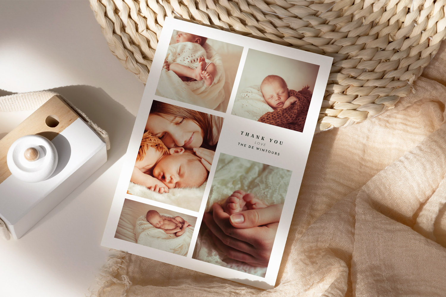 Baby thank you cards featuring a collage of newborn and family photos on a white card, styled on a neutral woven background.