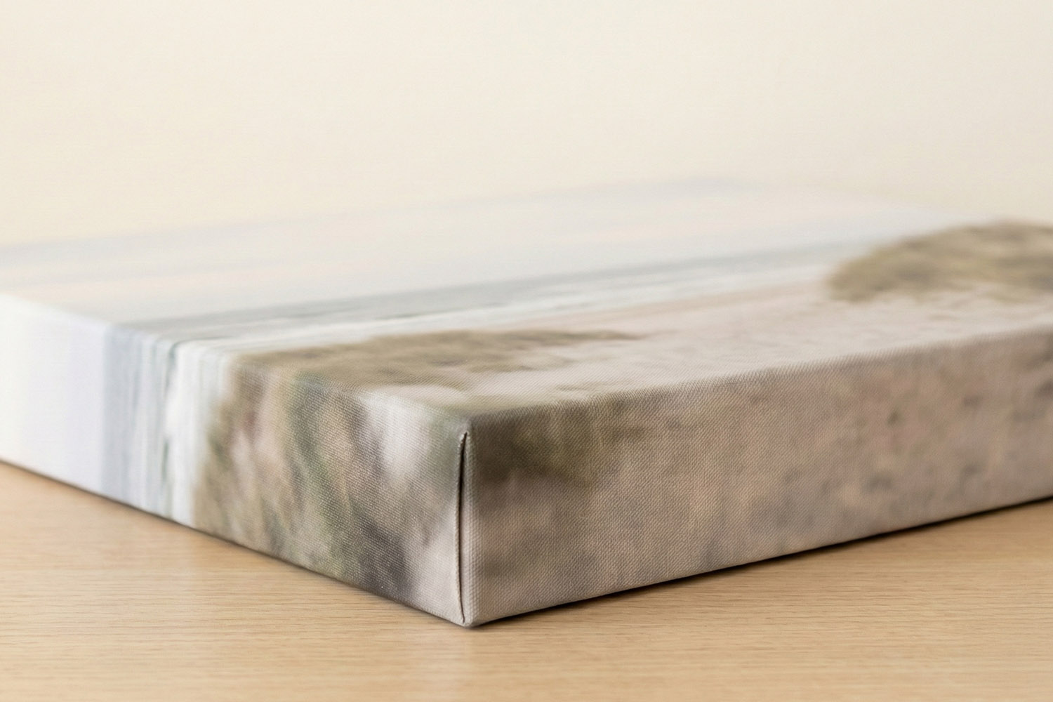 Canvas prints with wrapped edges showing a close-up of the corner detail on a stretched canvas on a wooden surface.