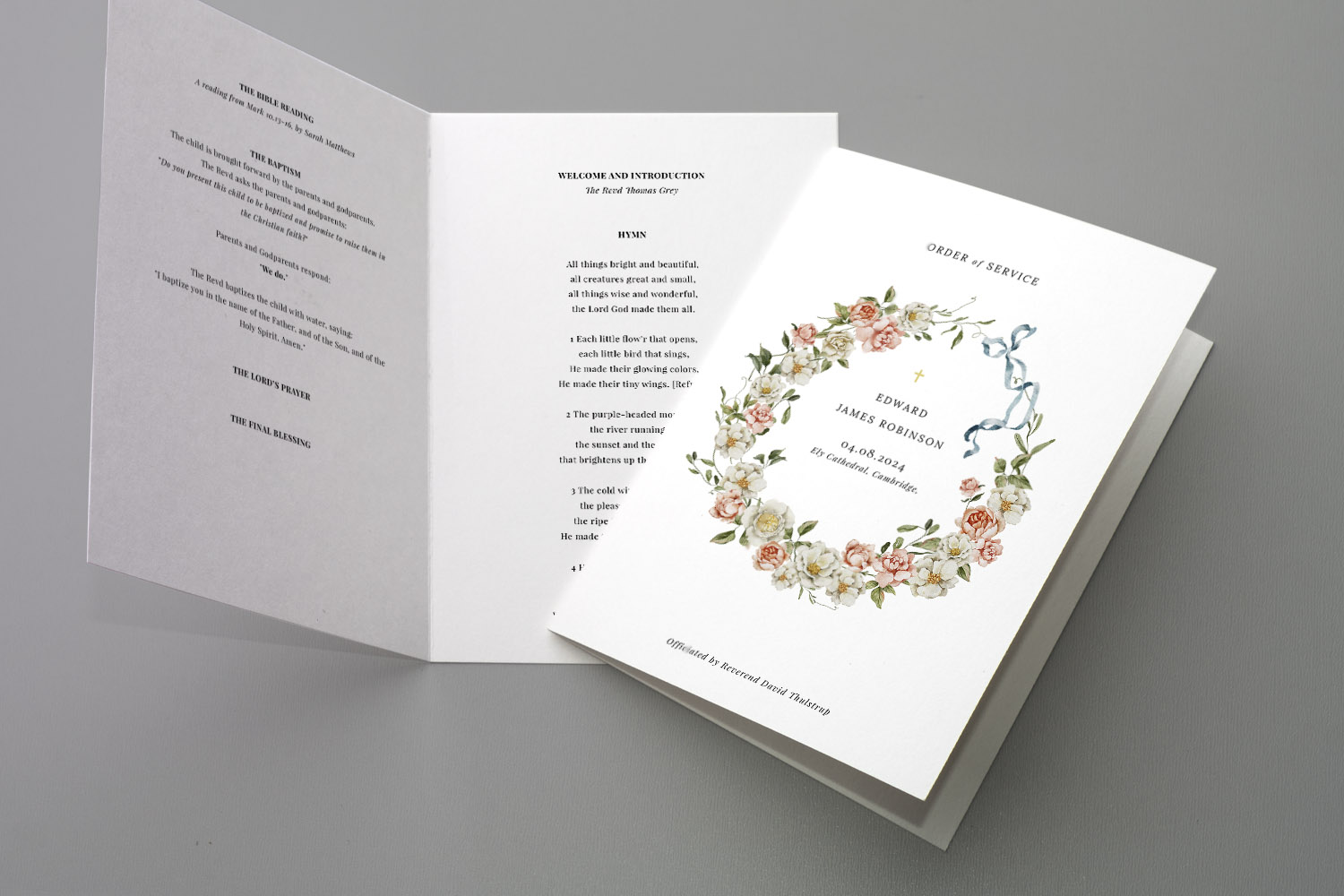 Christening order of service booklet with floral wreath design and personalised details, shown open on a light grey