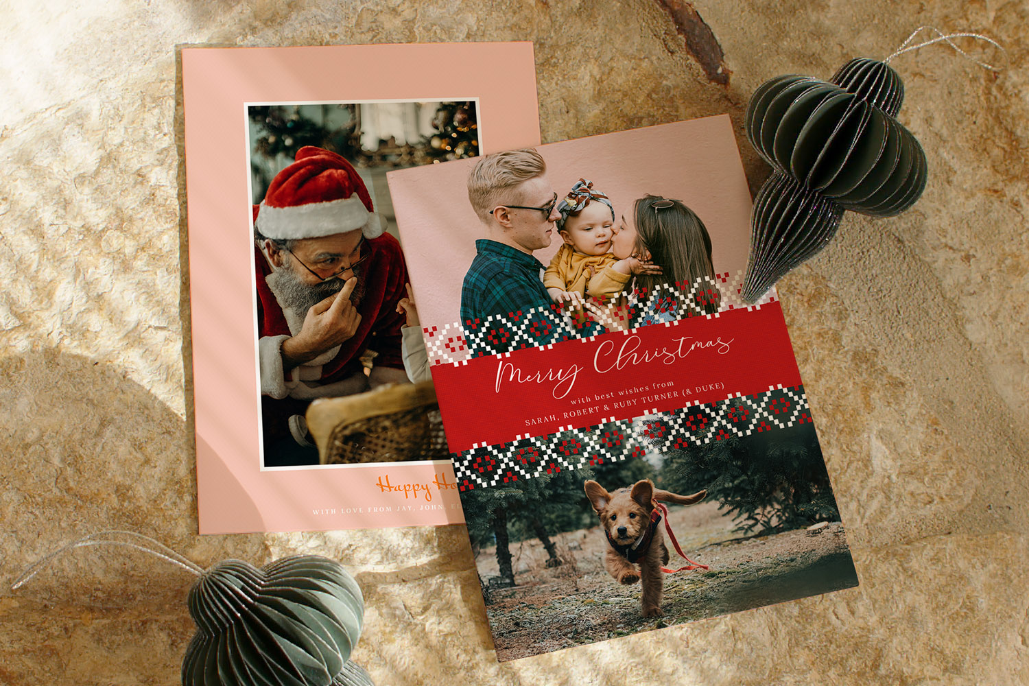 Christmas cards featuring personalised family photos and festive designs, displayed on a stone surface with paper