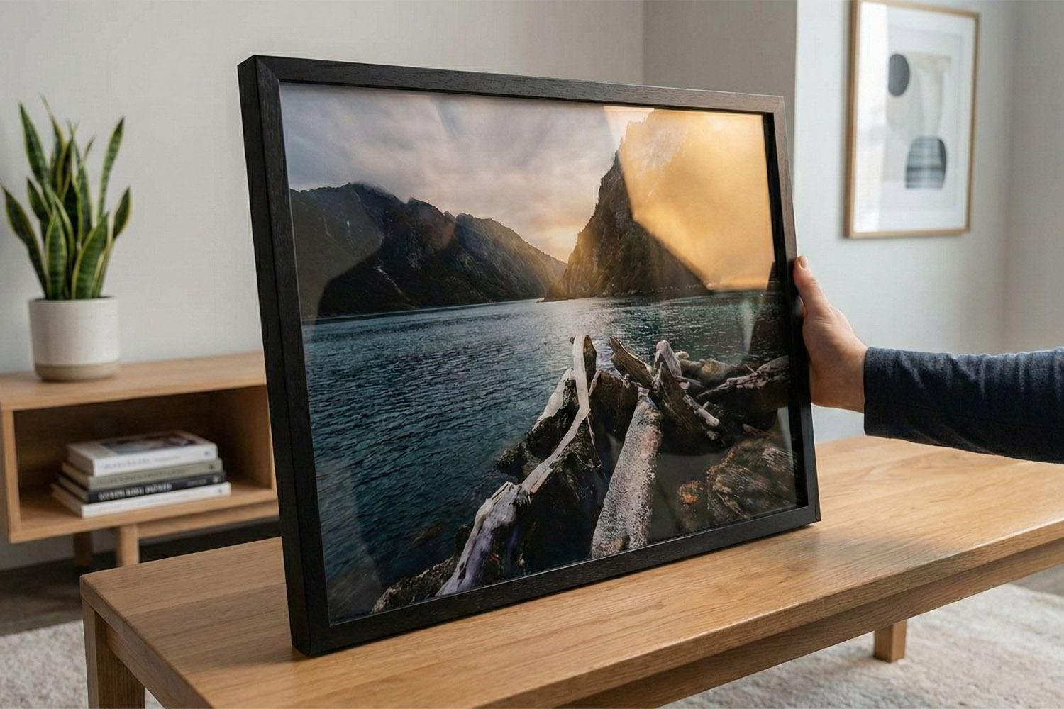 Framed and mounted prints featuring a landscape photograph with a black frame, displayed on a wooden table in a modern