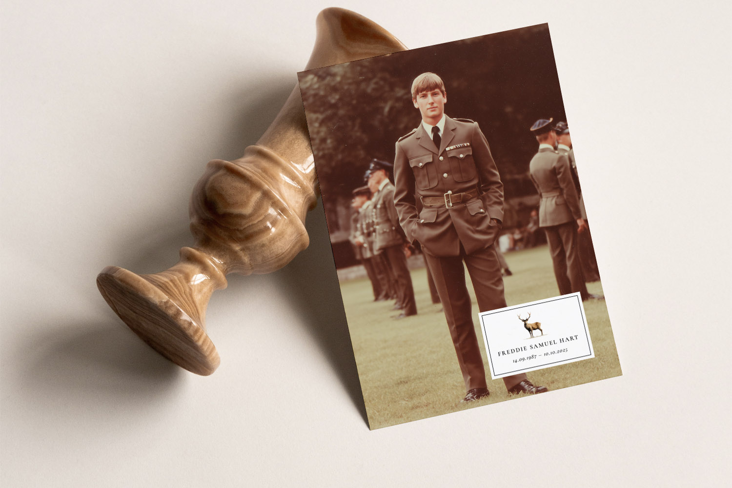 Funeral announcement card featuring a uniformed man standing outdoors, displayed beside a polished wooden urn on a neutral