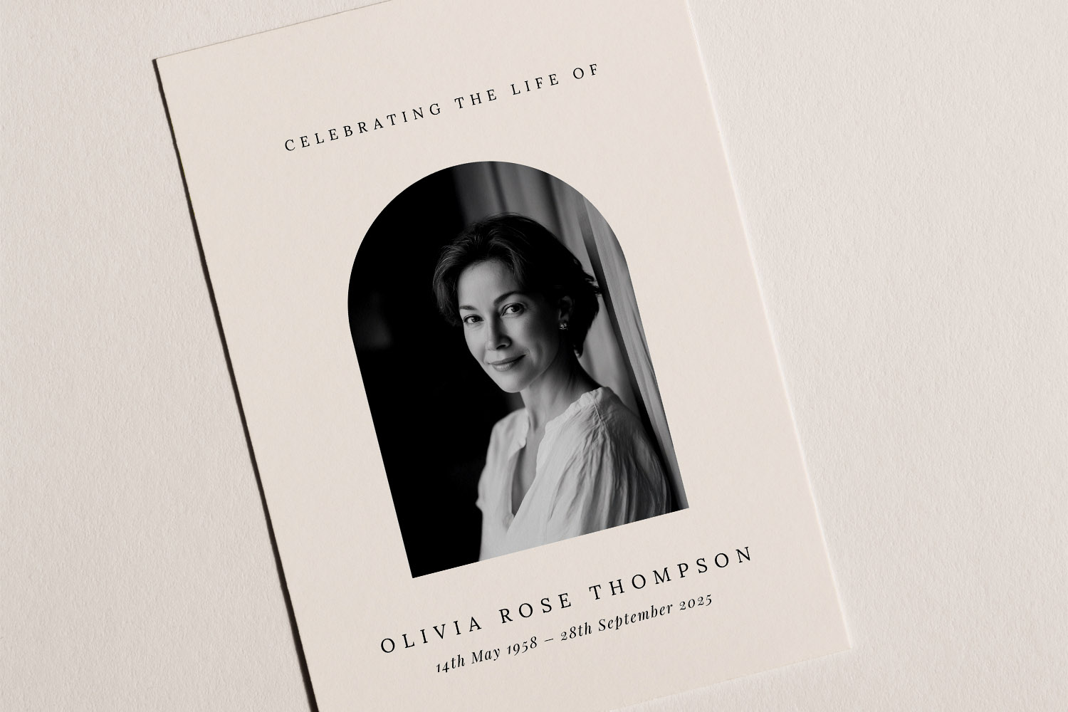 Funeral announcement card with a black and white portrait, arched photo window, and elegant serif text on cream paper.