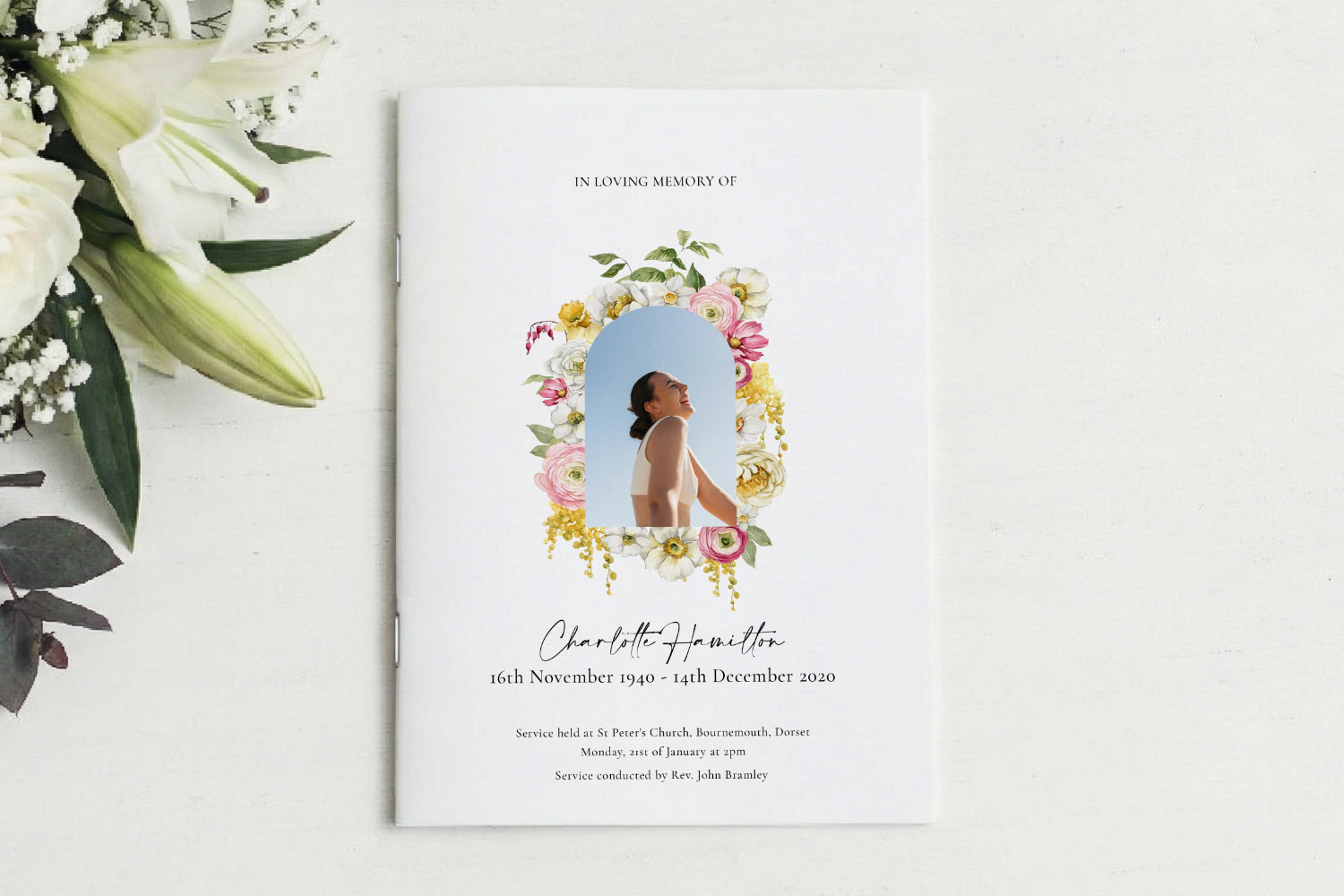 Funeral order of service booklet with a floral border, personal photo, and elegant script text on a white background