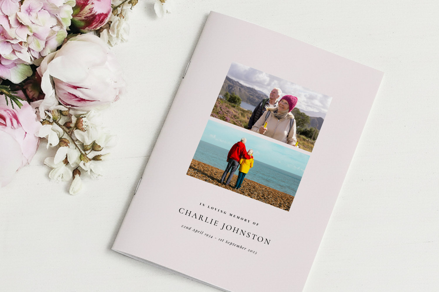 Funeral order of service booklet with two personal photos on a light cover, placed beside pink and white flowers on a table.