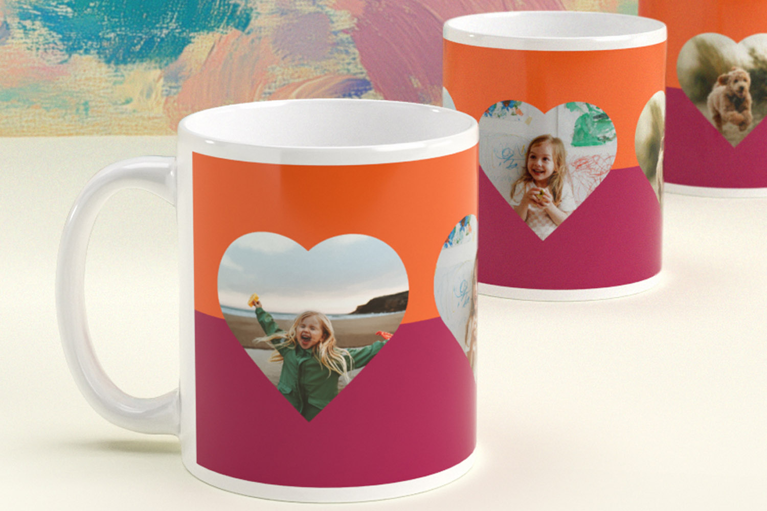 Personalised mugs with heart-shaped photo frames on orange and pink backgrounds, featuring custom images of children and