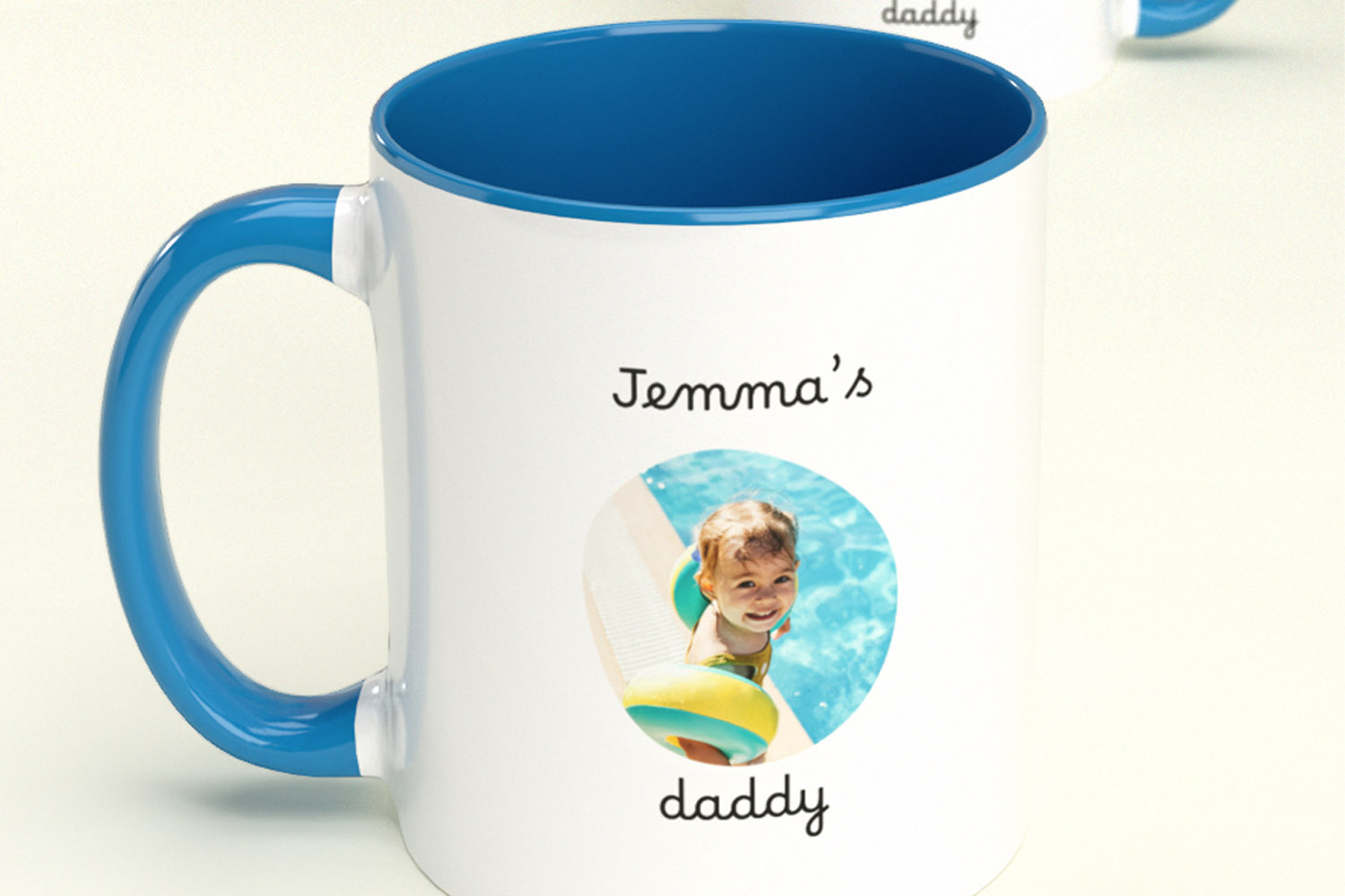 Personalised mugs with blue handle and rim, featuring a custom photo and text reading Jemma's daddy on a white background.