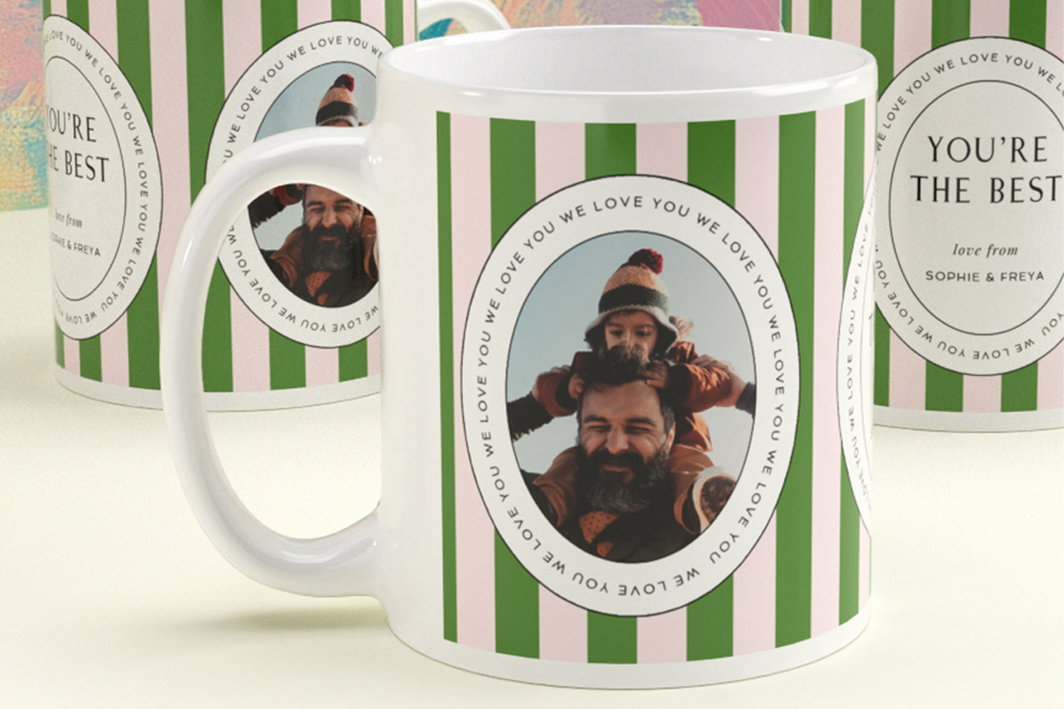 Personalised mugs with green and pink stripes, custom photo, and circular text reading we love you on a white ceramic base.