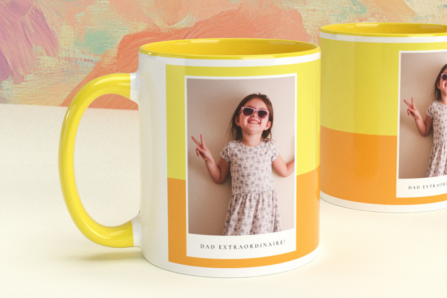 Personalised mugs with yellow and orange colour block design, featuring a printed photo of a smiling child wearing