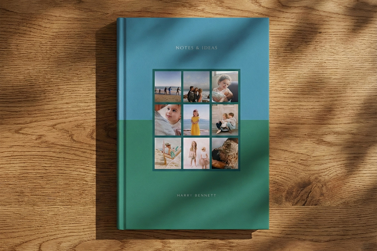 Personalised notebooks with blue and green cover, custom photo collage and name, displayed on a wooden surface