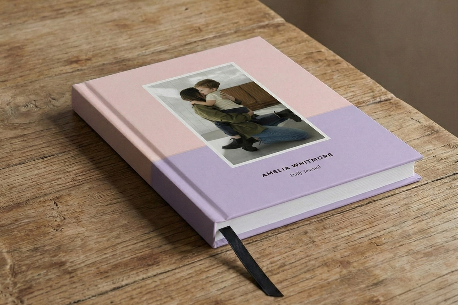 Personalised notebook with pastel pink and lavender hardback cover, custom photo, and black ribbon bookmark on a wooden table
