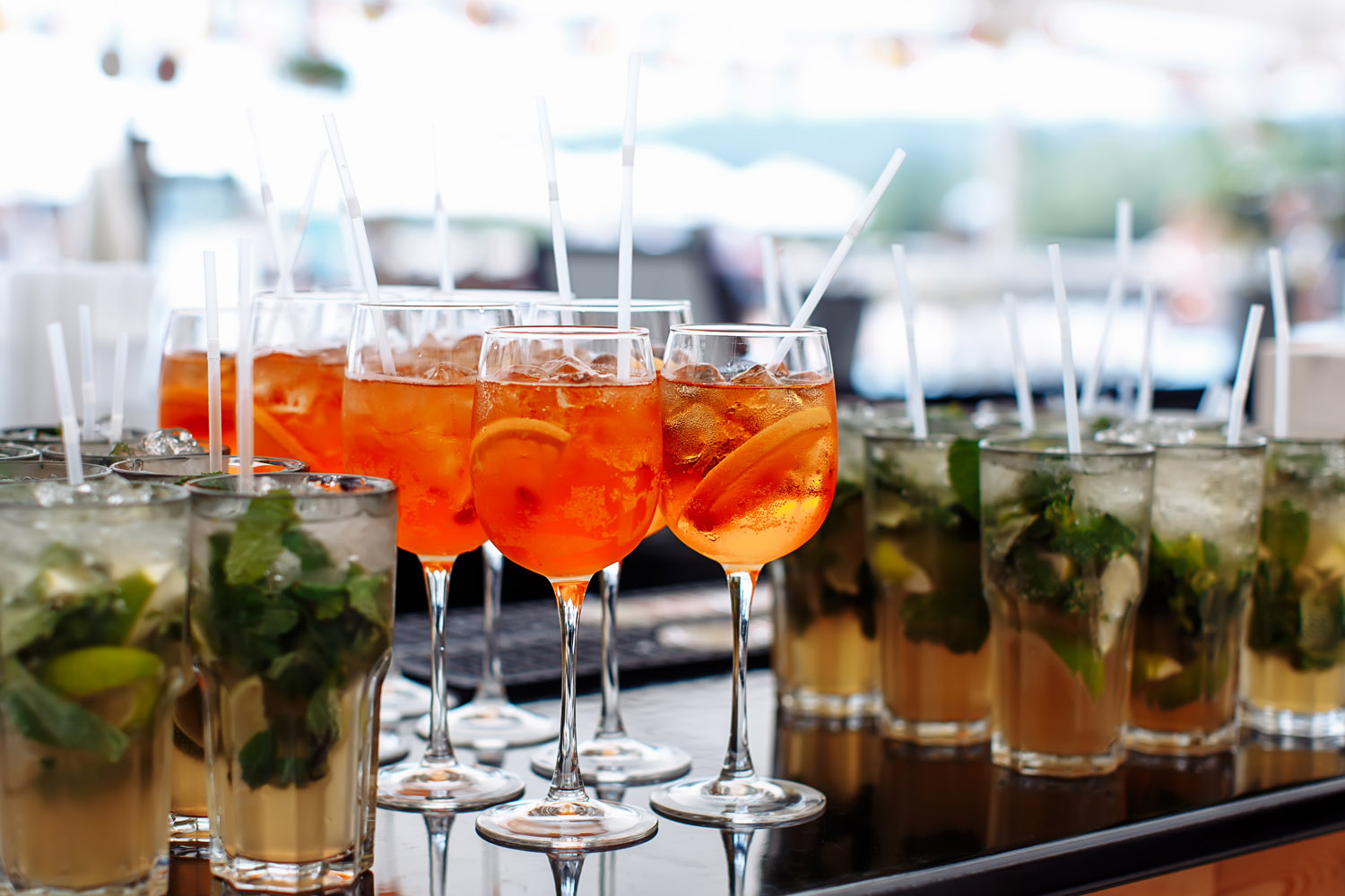 RSVP.studio event drinks selection with cocktails in tall glasses, featuring mojitos and spritz with fresh fruit and ice