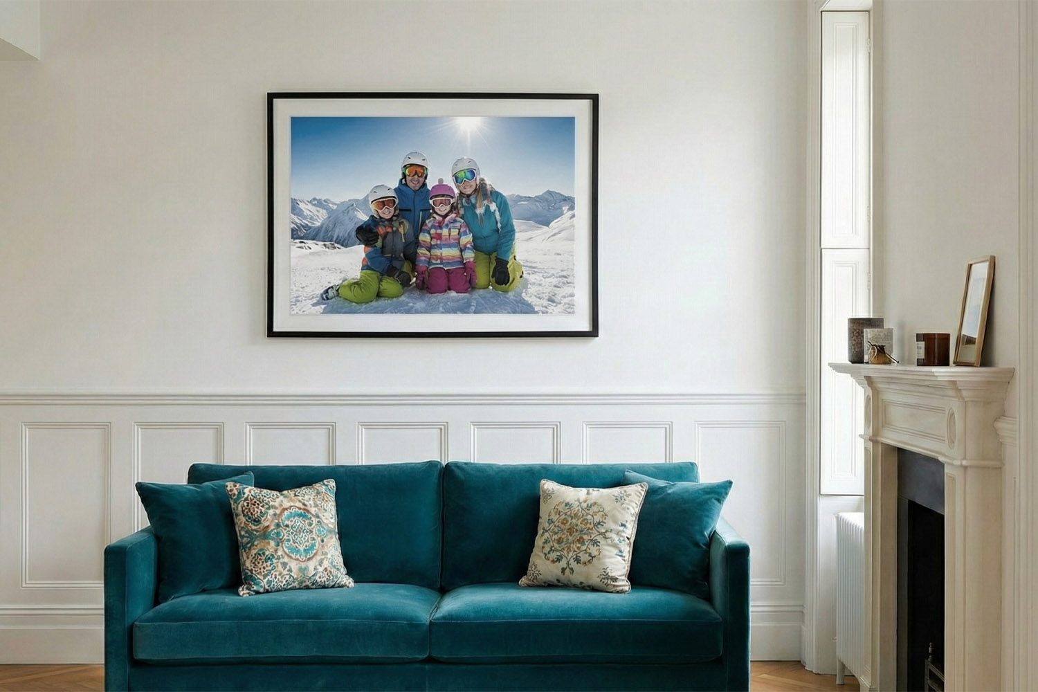 Simple framed prints featuring a family ski holiday scene, displayed above a teal sofa in a modern living room setting.