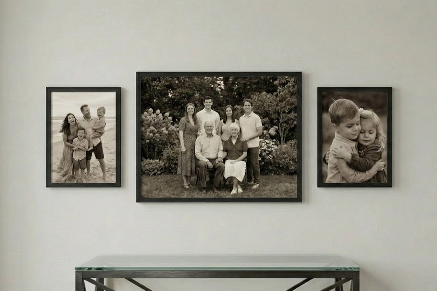 Simple framed prints with black borders displayed on a light wall, featuring black and white family portraits.