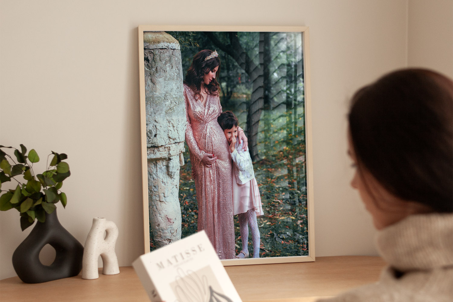 Simple framed prints featuring a family portrait in a light wood frame, displayed on a wooden desk with decorative accents.