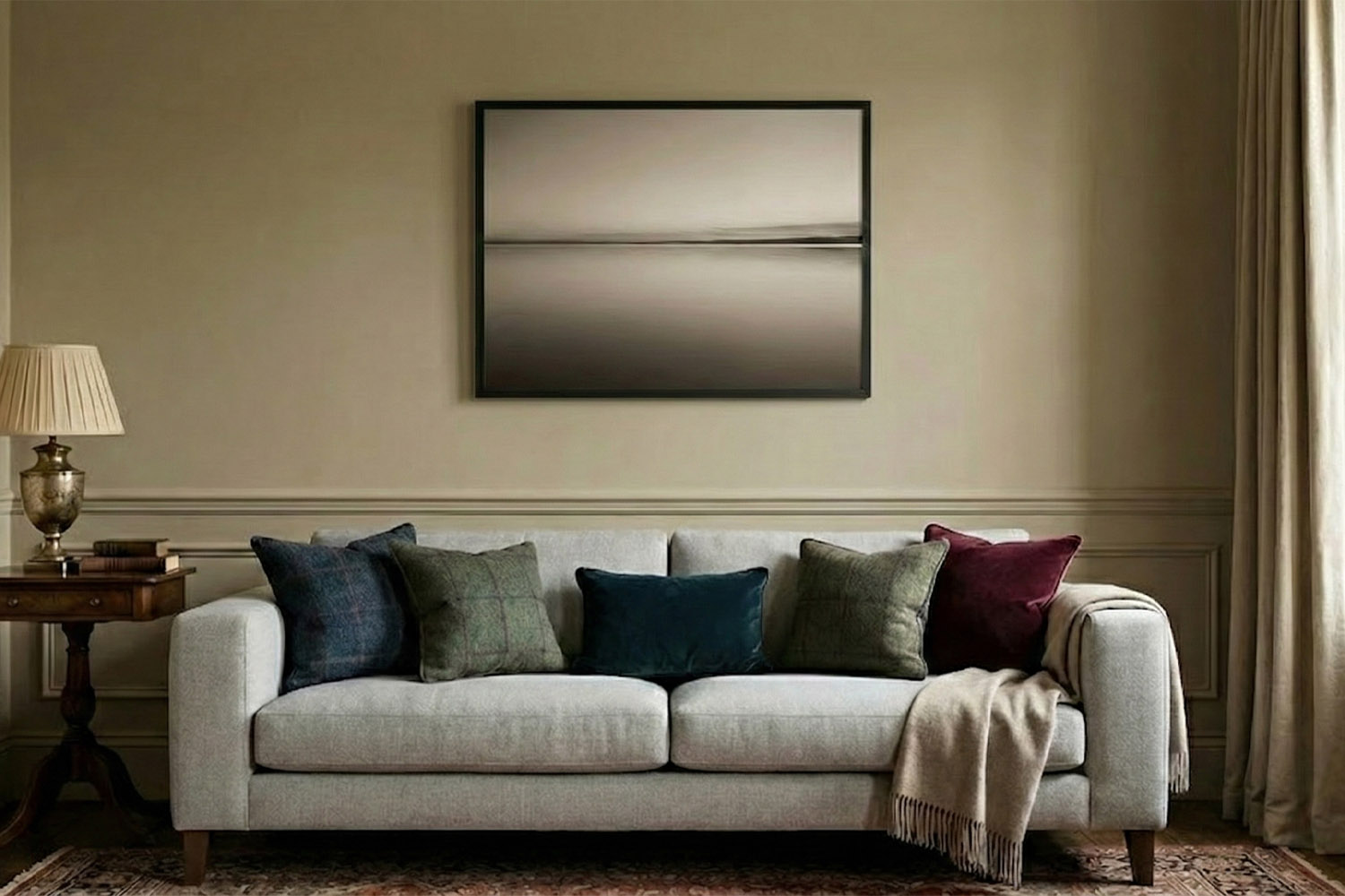 Simple framed prints featuring a minimalist landscape in a black frame, hung above a neutral sofa in a stylish living room.