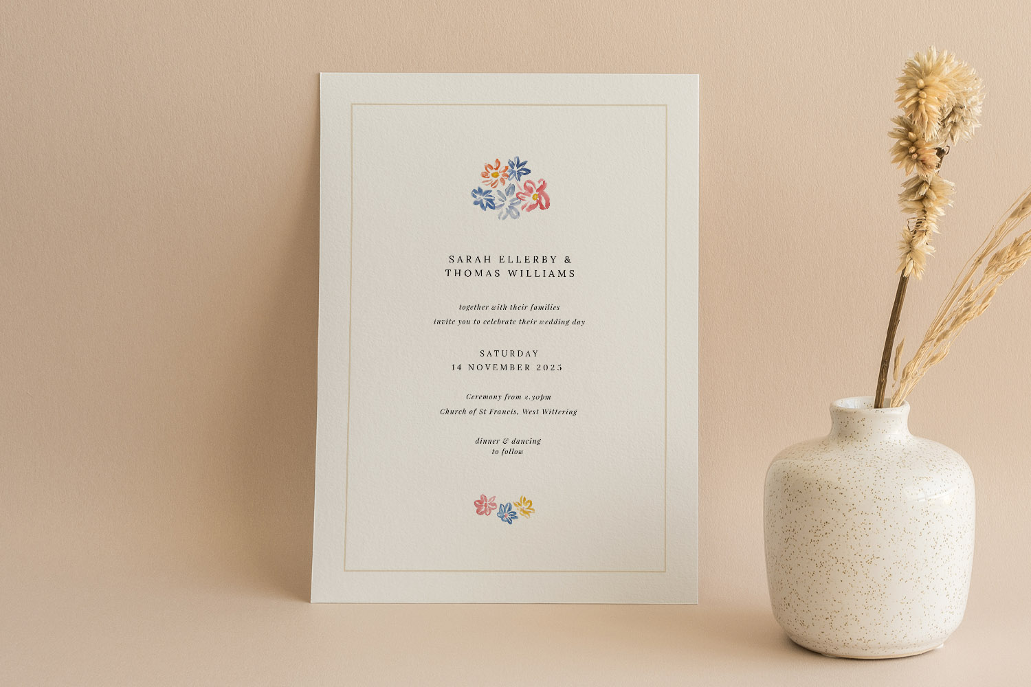 Wedding invitations with minimalist cream card, delicate floral accents, and elegant serif text, styled beside a ceramic