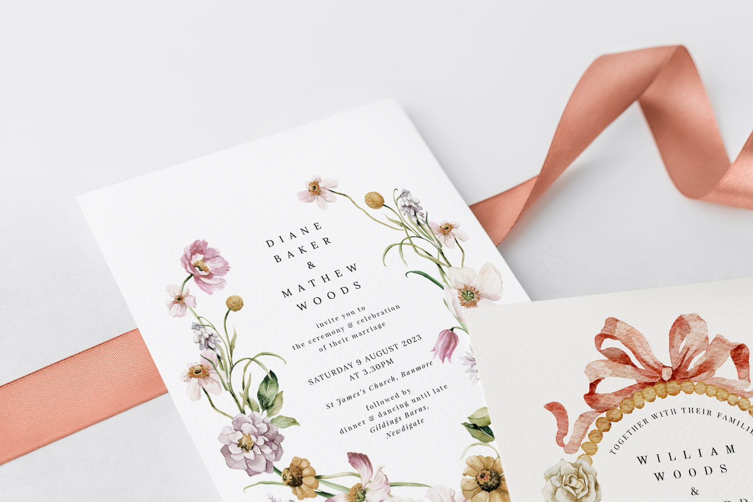 Wedding invitations with elegant floral designs and delicate typography, displayed on white textured card with a peach