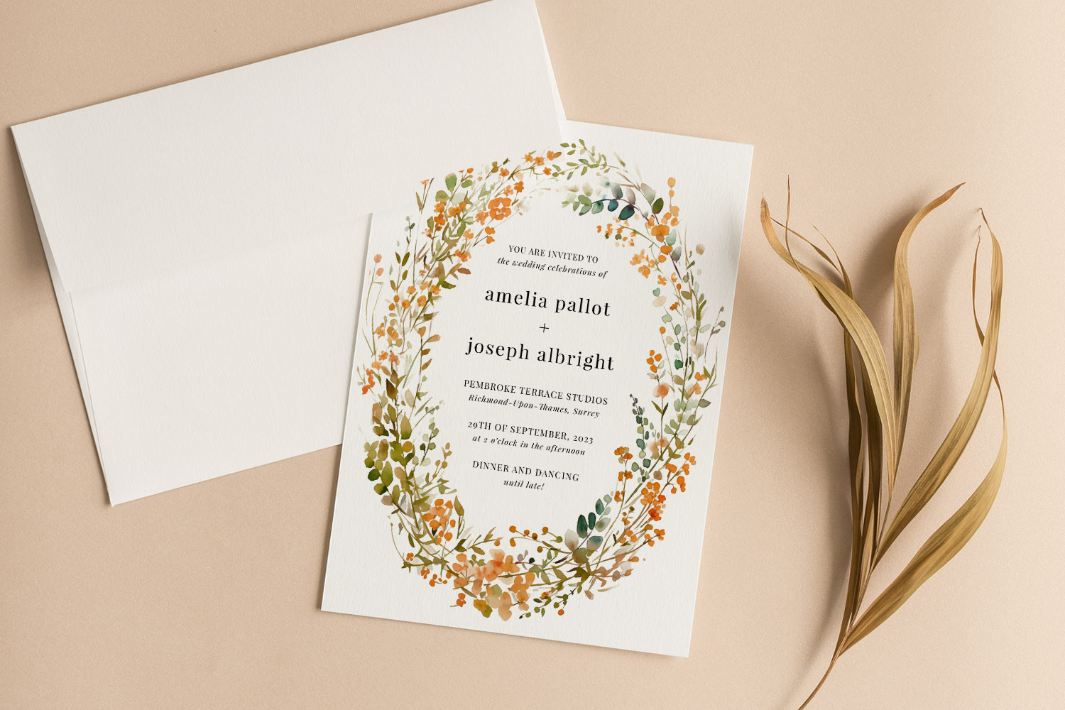 Wedding invitations with a botanical wreath design in orange and green on textured white card, paired with a matching