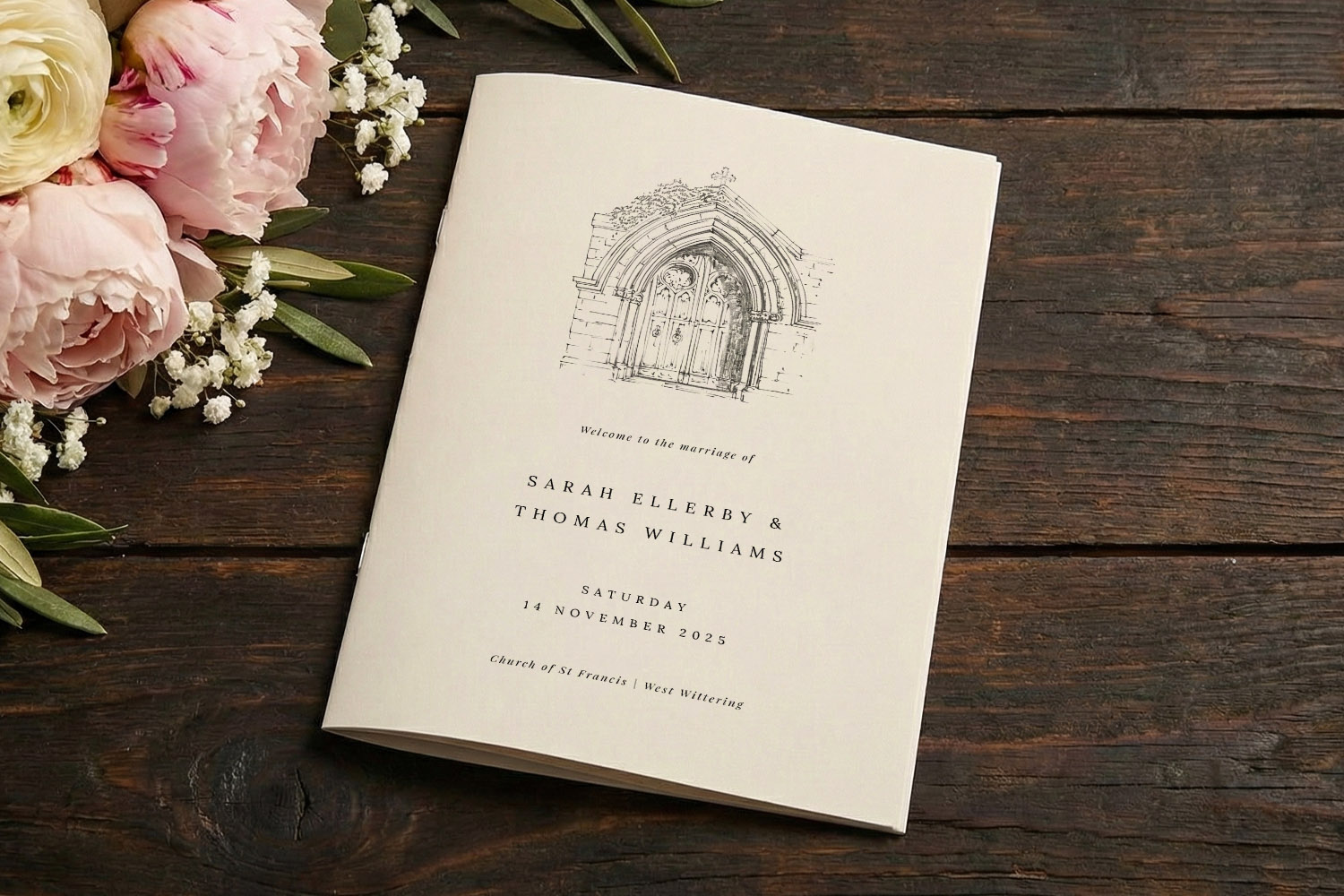 Wedding order of service booklet with illustrated church doorway, personalised text, on rustic wooden table beside pink