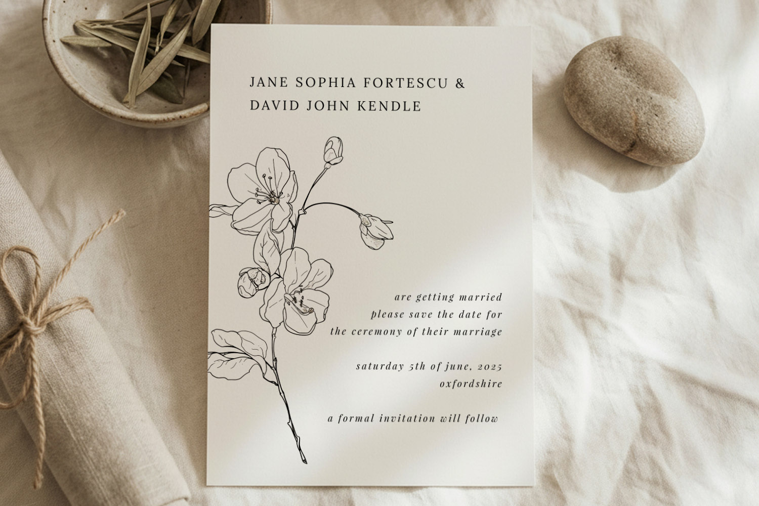 Wedding save the dates card with minimalist floral illustration and elegant typography on cream paper, styled with natural