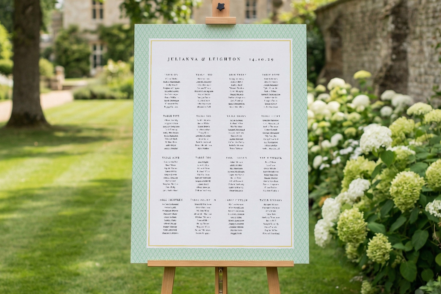 Wedding table plan with a green patterned border displayed on an easel in a garden setting, listing guest names and tables.