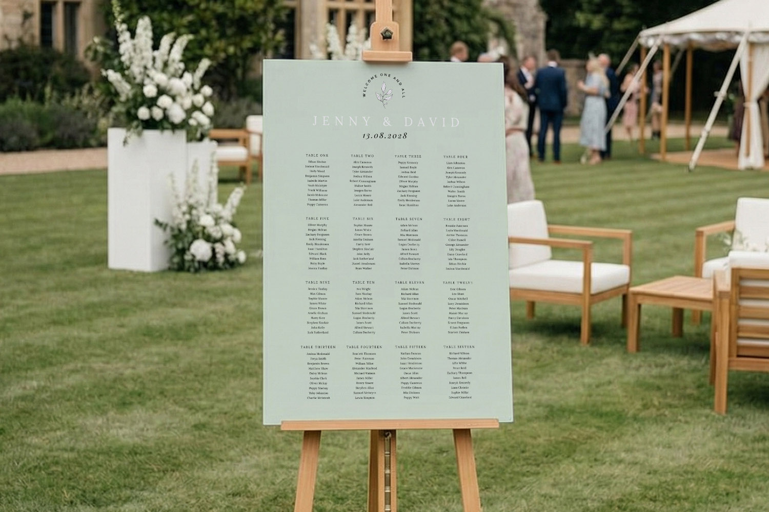 Wedding table plan with minimalist typography on a pale green board, displayed on an easel at an outdoor reception venue.