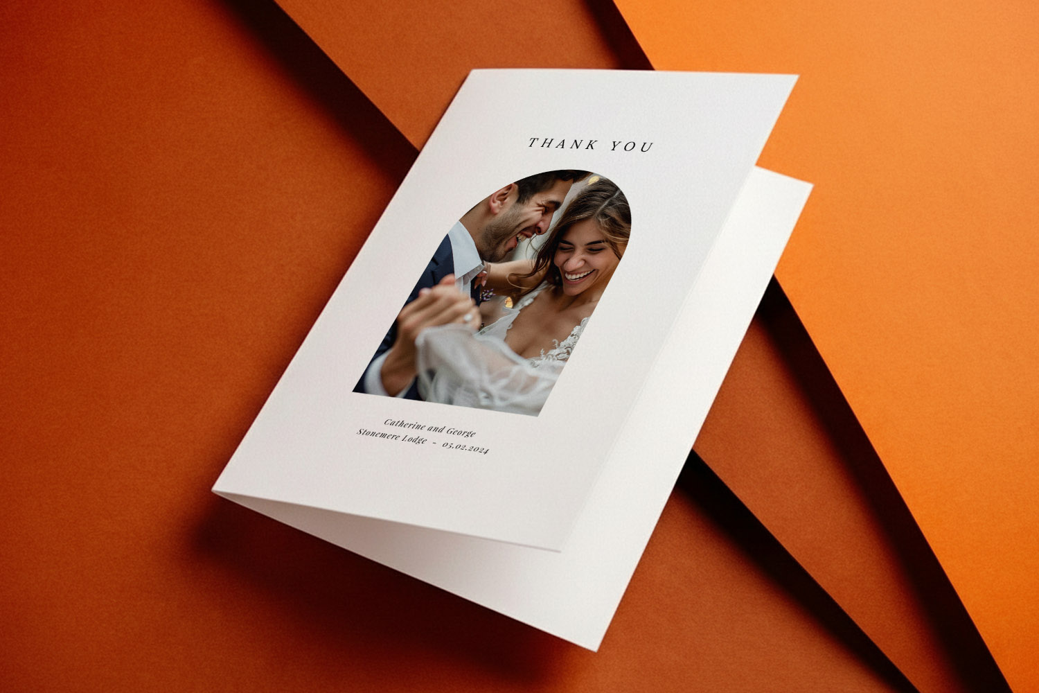 Wedding thank you cards with a personalised photo and elegant typography on white card, displayed on an orange background.