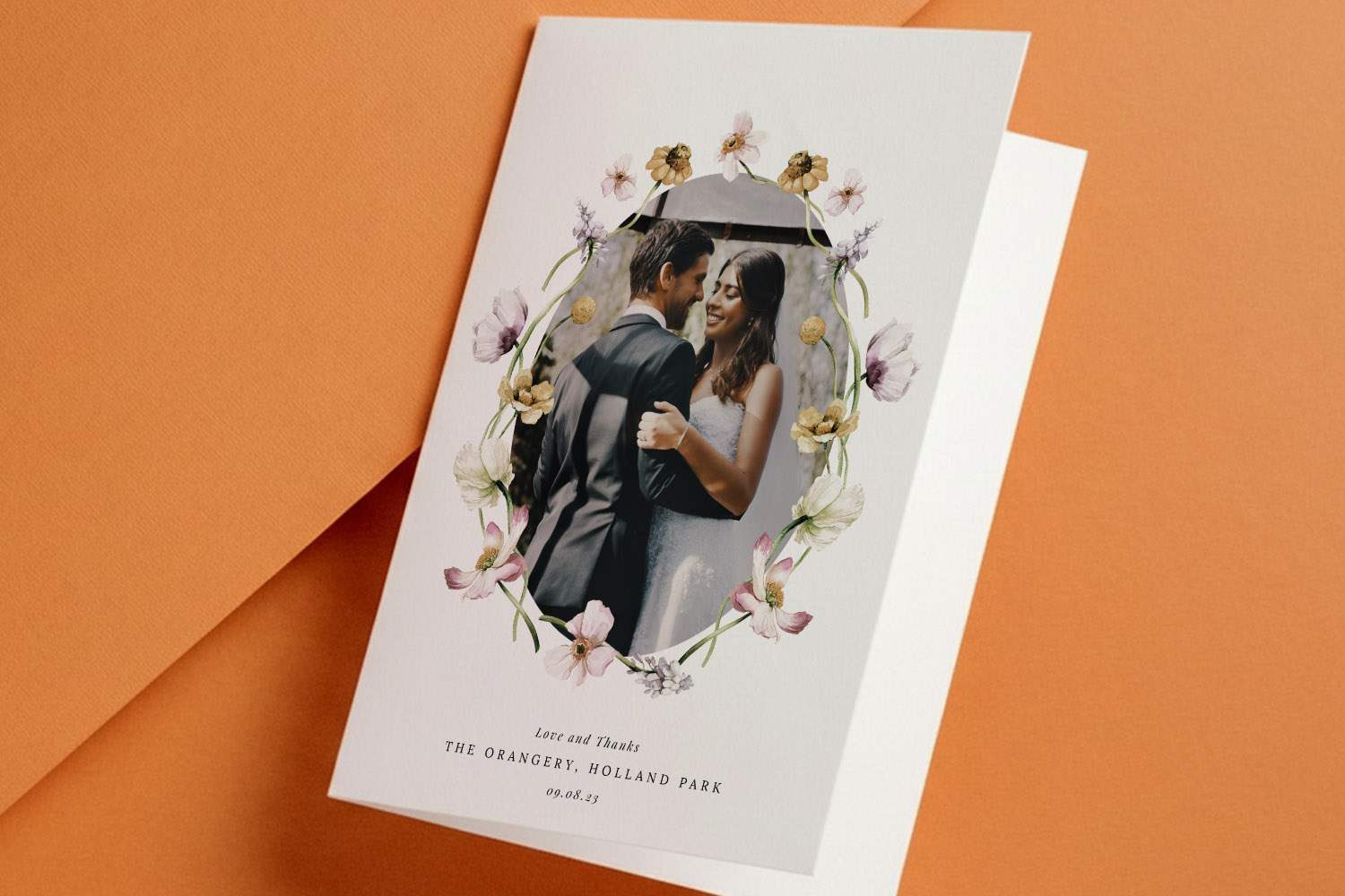 Wedding thank you cards with a floral border and personalised photo of a bride and groom embracing on a white card