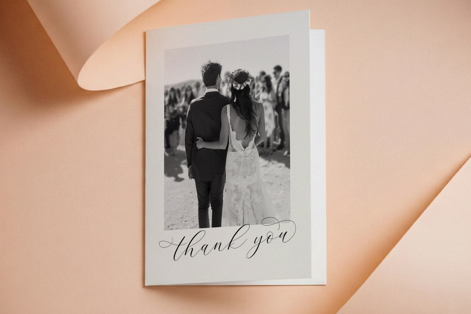 Wedding thank you cards featuring a black and white photo of a couple with elegant script text on a soft peach background.