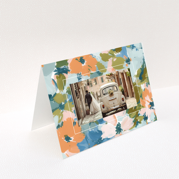 Wedding invitation design with floral border and a photo of a couple by a vintage car.